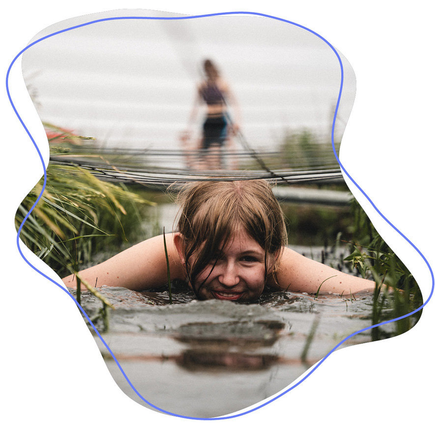 Mädchen liegt lächelnd im Wasser auf der Dunedays-Freizeit beim WDL-Dünenhof