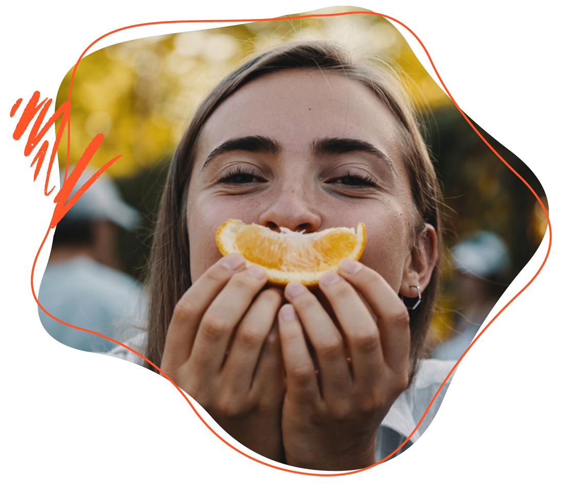 Frau die eine Orange in der hand hat 