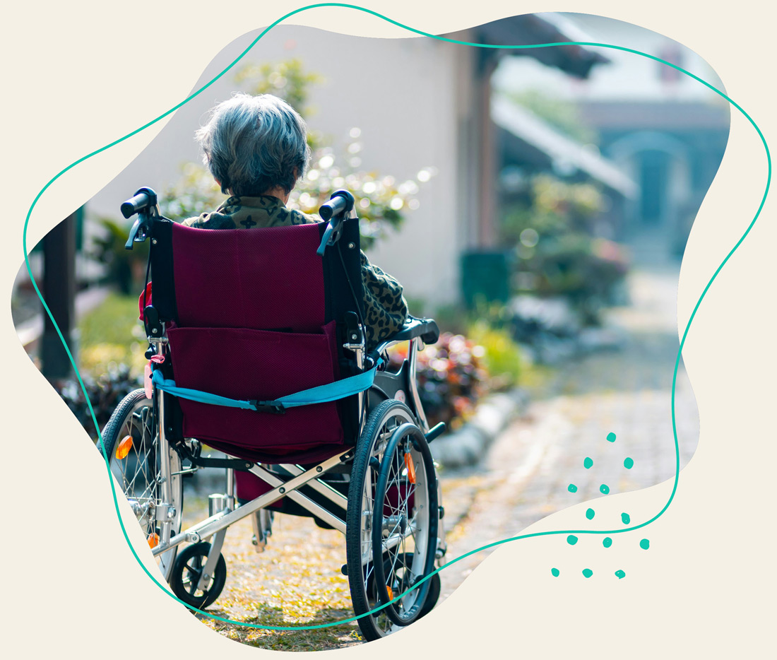 Eine ältere Frau sitzt im Rollstuhl und genießt die Aussicht