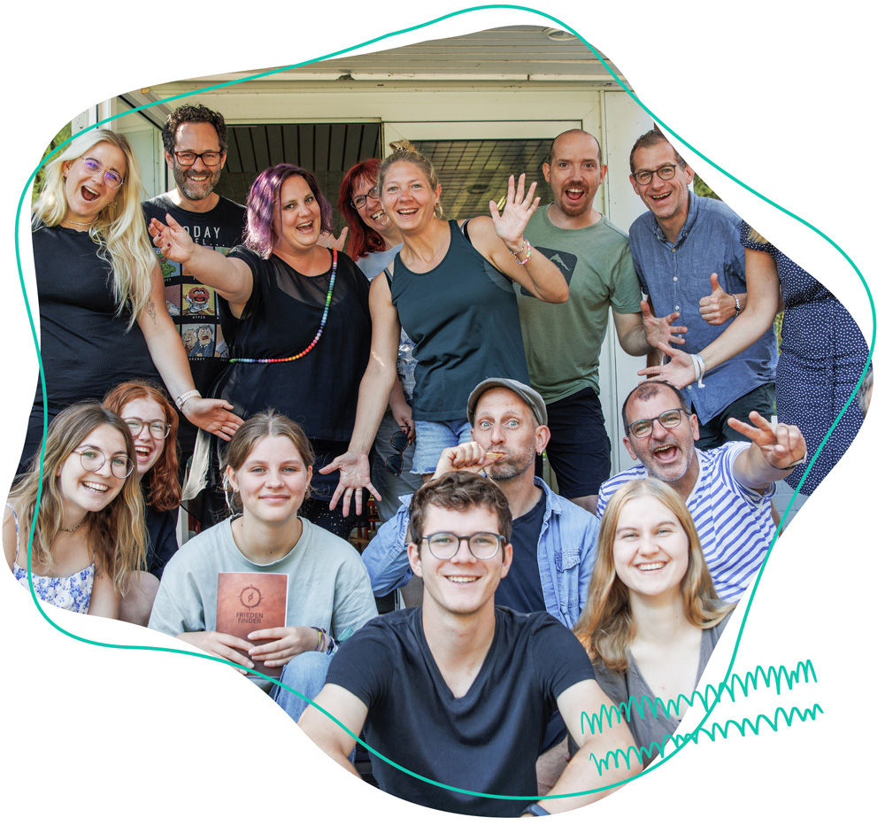 Gruppe strahlt fröhlich in die Kamera vor dem Eingang von den Gruppenhäusern beim WDL Dünenhof