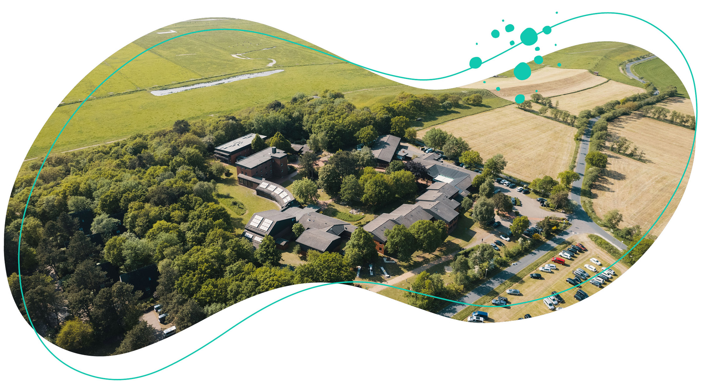 Der WDL-Dünenhof ist aus der oberen Perspektive mit einer Weidelandschaft im Hintergrund abgebildet.