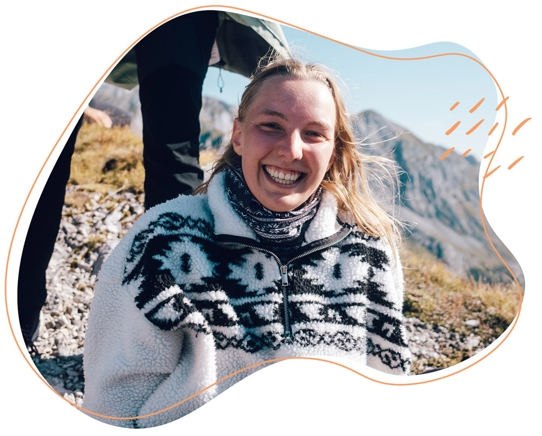 Eine Frau sitzt im Hintergrund ein Berg 