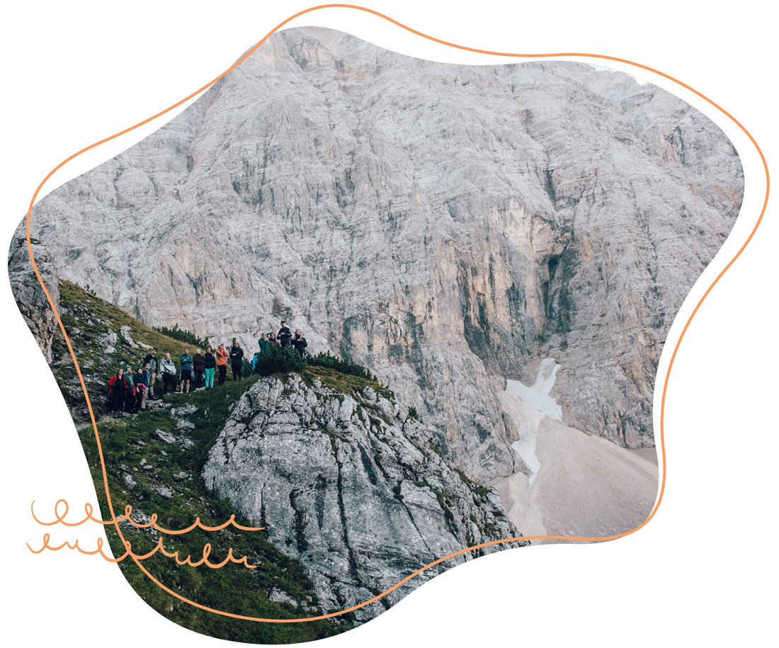 eine Gruppe mit jungen Erwachsenen steht auf einen Berg