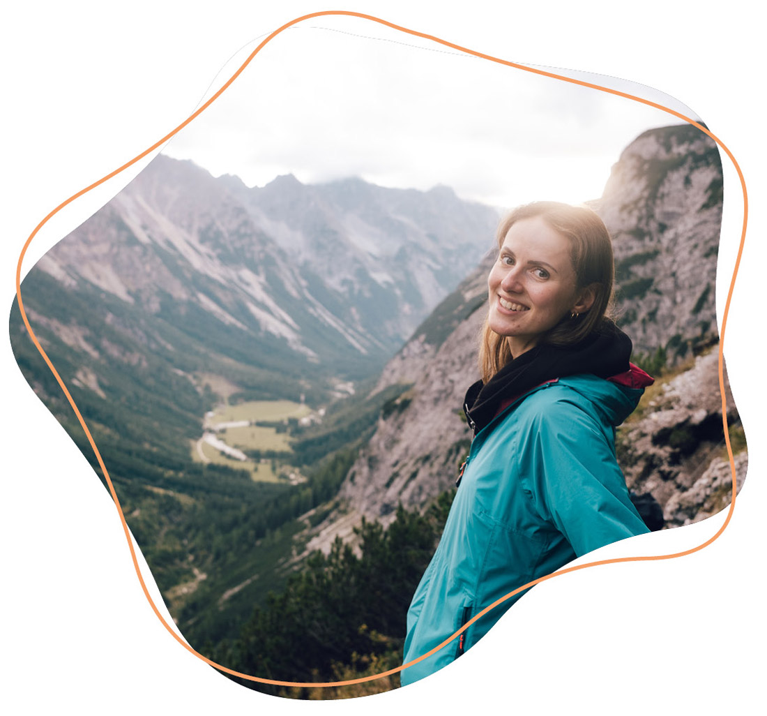 Frau lehnt sich an einem Fels 