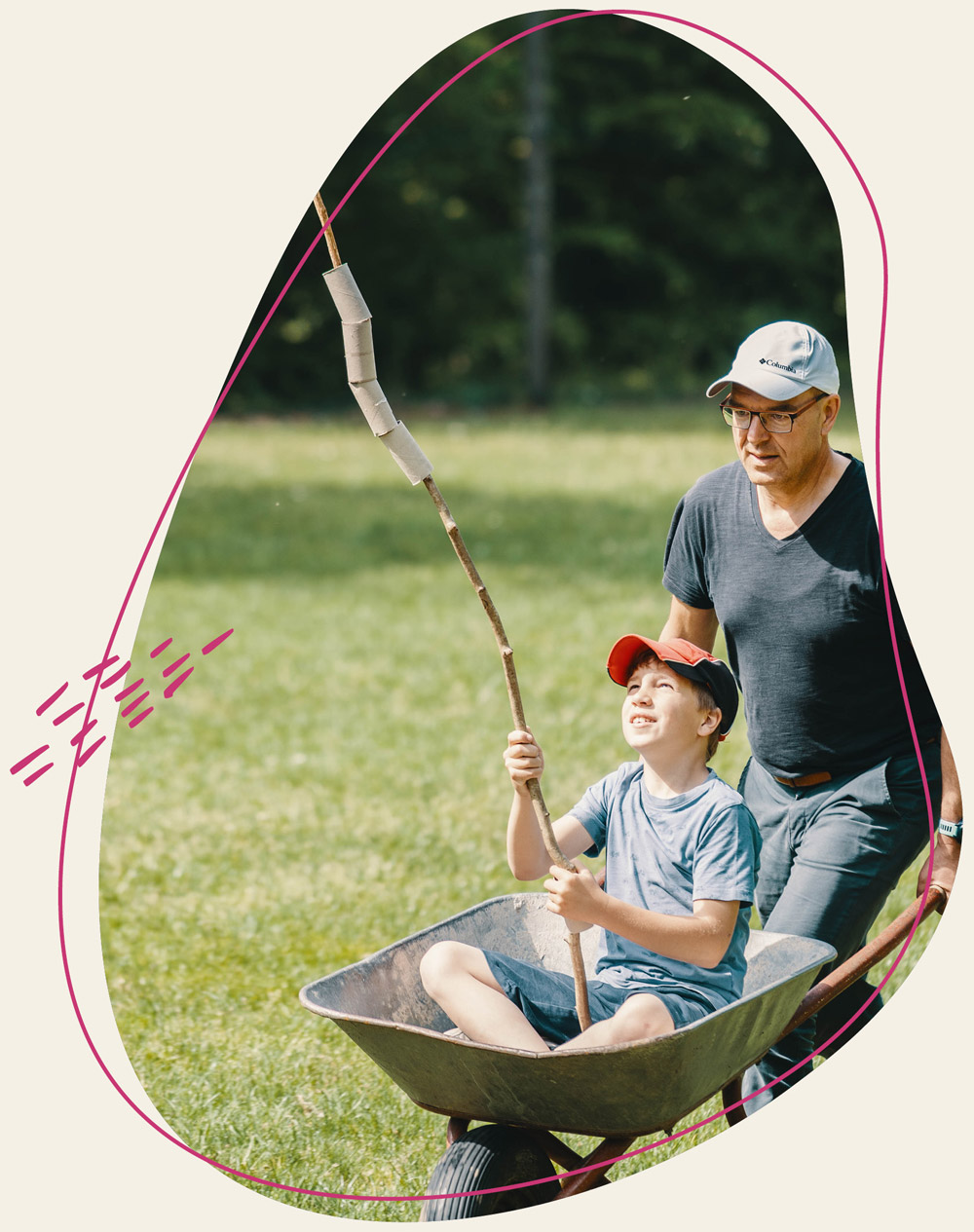 Mann schiebt ein Kind in einer Schubkarre