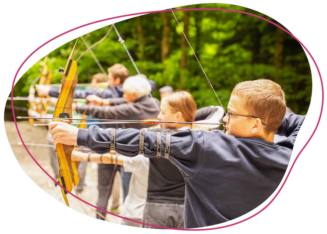 Kinder die mit Pfeil und Bogen schießen 