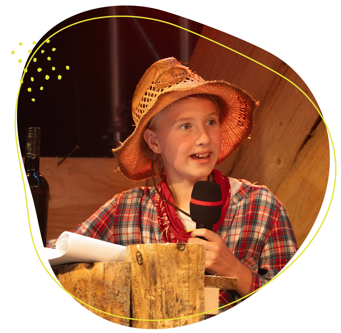 Junge redet ins Mikro und ist verkleidet als Bauer