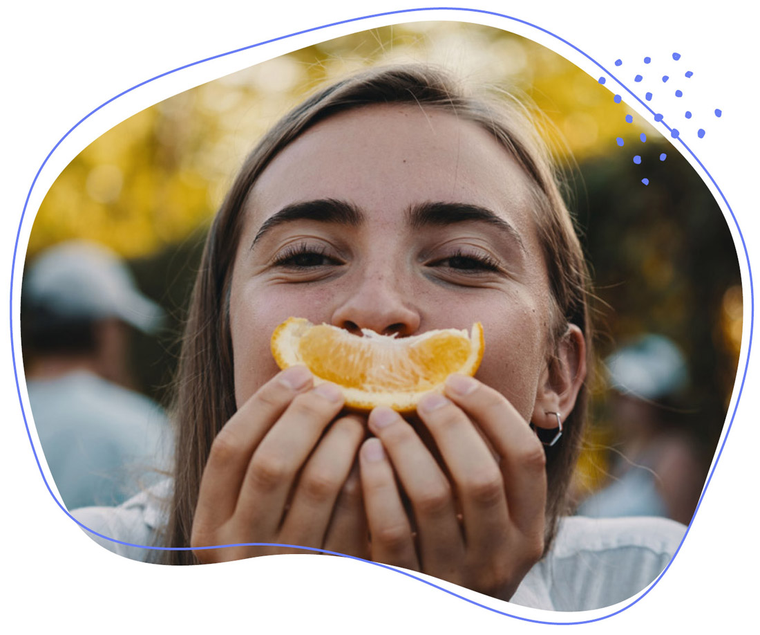 Frau die eine Orange in der hand hat 