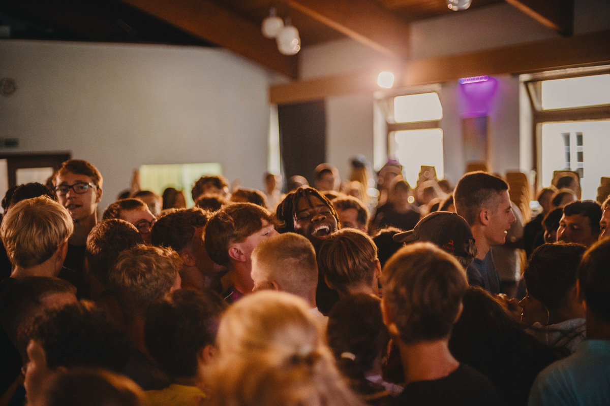 Kinder sitzen in einem Saal und lachen