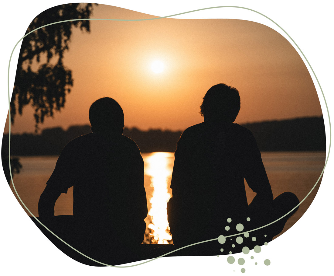 zwei männer schauen dem Sonnenuntergang zu