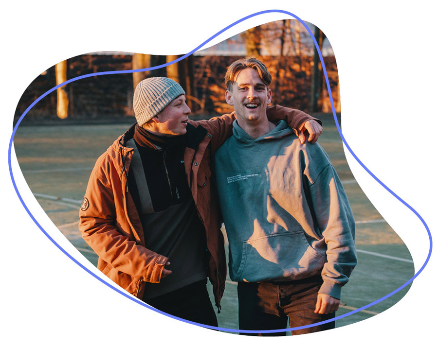 zwei Jugendliche lächeln in die Kamera