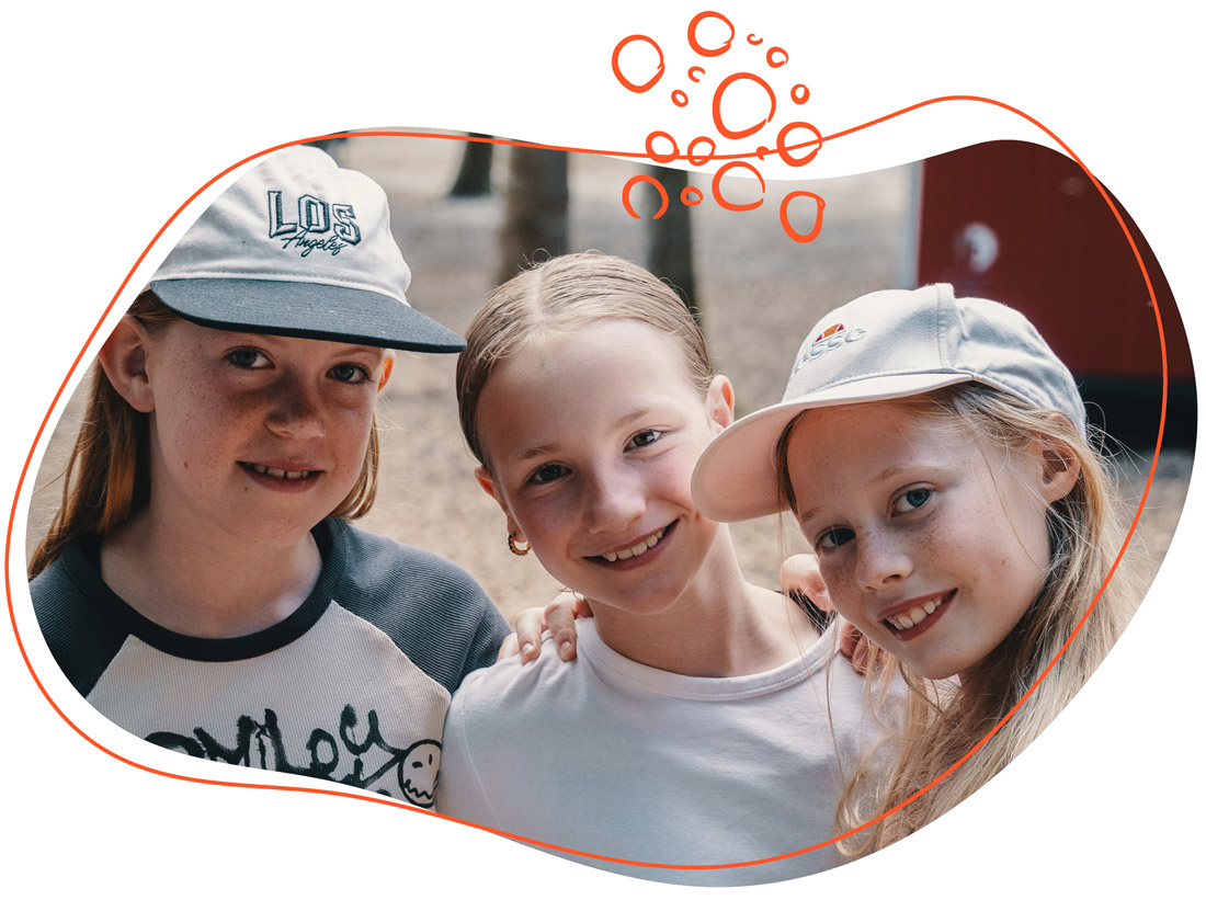 Mädchengruppe lächeln im Wagendorf bei einer Kinder-Sommerfreizeit